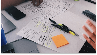 UI/UX team planning with laptops and papers to brainstorm design ideas